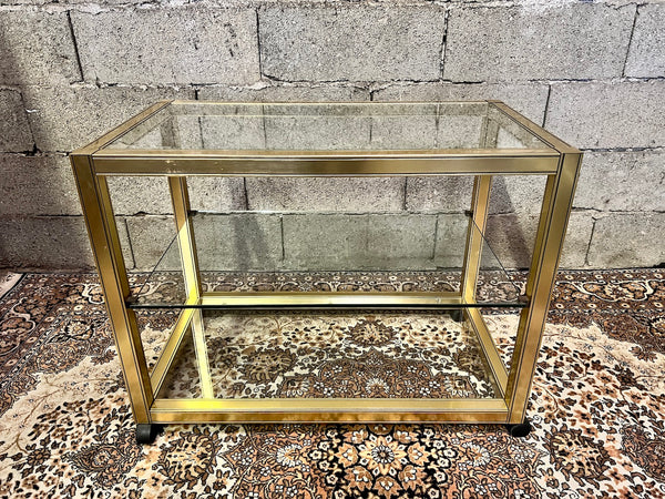 Table basse en métal doré et verre sur roulettes dans le style de Pierre Vandel